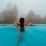A metà ottobre la maggior parte delle piscine private è già chiusa. I teli sono stesi, gli impianti di filtrazione rallentano o si fermano, e per qualche mese la vasca esce dai pensieri di chi la possiede. Proprio in questo periodo, però, si apre la finestra migliore per occuparsi del suo rivestimento: l'estate è lontana, nessuno aspetta di fare il bagno e i lavori si possono programmare senza fretta. Lo stesso vale per fontane, vasche ornamentali e specchi d'acqua da giardino, che in autunno si svuotano per la pulizia o per lo svernamento. Una vasca vuota mostra tutto ciò che l'acqua nasconde durante la stagione: distacchi, fessure, bordi consumati, scarichi che hanno perso tenuta. Vedere questi segni a ottobre significa avere il tempo di intervenire bene. Scoprirli a maggio, con la piscina da riempire, significa quasi sempre rincorrere il calendario. Rivestimento piscine in resina: perché la fine della stagione è il momento giusto Il primo vantaggio riguarda i tempi. Un rivestimento piscine in resina richiede diverse fasi, dalla preparazione del supporto alla maturazione finale del ciclo, e ognuna ha i suoi tempi tecnici. Lavorare in autunno permette di rispettarli tutti, senza comprimere le attese per rientrare in una data di apertura. Il secondo vantaggio è organizzativo. In primavera le richieste si concentrano e i cantieri si accavallano: chi arriva tardi rischia di trovare il calendario pieno o di dover accettare tempi più stretti del necessario. Programmare il rifacimento della vasca alla chiusura della stagione mette al riparo da questo imbuto. C'è infine una ragione tecnica. Dopo mesi di esercizio, lo stato del rivestimento è leggibile con la massima chiarezza: si vede dove il colore si è alterato, dove la superficie è diventata ruvida, dove l'acqua ha lasciato depositi o dove il livello è calato più del previsto. Sono informazioni preziose per decidere se basta un intervento di manutenzione o se serve un rifacimento completo. Le condizioni climatiche vanno comunque tenute d'occhio. La maggior parte dei sistemi in resina richiede temperature del supporto e dell'aria sopra una soglia minima indicata dal produttore e superiori di qualche grado al punto di rugiada. Per questo conviene muoversi entro l'autunno: se il freddo arriva prima del previsto, il lavoro si completa in primavera, con la diagnosi già fatta e il cantiere già organizzato. Valutare il rivestimento esistente a vasca vuota Ogni intervento parte da un sopralluogo con la vasca svuotata e pulita. Non tutte le piscine hanno bisogno di un rivestimento nuovo, e non tutti i rivestimenti invecchiati vanno rimossi. La valutazione serve a distinguere i casi. Cosa si osserva sulla superficie Stato della finitura: sfarinamento, ruvidità al tatto, perdita di brillantezza, variazioni di colore dovute ai raggi UV o ai prodotti di trattamento. Continuità dello strato: fessure, graffi profondi, zone in cui il rivestimento si è assottigliato fino a lasciare intravedere il fondo. Adesione: bolle, rigonfiamenti, parti che suonano vuote alla battitura o che si sollevano facendo leva con una spatola. Depositi e incrostazioni: calcare lungo la linea d'acqua, macchie di ferro o di alghe, residui che indicano un equilibrio chimico dell'acqua da rivedere. Il supporto sotto il rivestimento La tenuta di un rivestimento dipende dal supporto su cui è applicato. Nelle vasche in calcestruzzo si verifica la presenza di fessure strutturali, ferri d'armatura affioranti, nidi di ghiaia o zone degradate. Nelle piscine rivestite in piastrelle o mosaico si controlla che le piastrelle siano ben ancorate e che le fughe non si siano svuotate. Se la vecchia finitura è una vernice, uno smalto o un'altra resina, bisogna capire di che prodotto si tratta, perché non tutti i materiali accettano di essere ricoperti. Da questa verifica dipende la scelta fra due strade: applicare il nuovo ciclo sopra l'esistente, dopo un'accurata preparazione, oppure rimuovere il vecchio rivestimento fino a tornare al supporto sano. Distacchi e perdite d'acqua: i segnali da non trascurare Bolle e distacchi Un rivestimento che si stacca in una piscina ha quasi sempre una causa precisa. Le più frequenti sono l'umidità nel supporto al momento della posa, una preparazione insufficiente della superficie, l'incompatibilità fra il nuovo prodotto e quello sottostante oppure la spinta dell'acqua che arriva da dietro, attraverso le pareti della vasca, quando il terreno circostante è saturo. Rimuovere le parti staccate e riapplicare lo stesso prodotto nello stesso modo, senza capire perché si sono staccate, porta allo stesso risultato nel giro di una o due stagioni. Come capire se la vasca perde Un calo del livello dell'acqua durante l'estate è normale fino a un certo punto: evaporazione, schizzi e controlavaggi del filtro consumano ogni giorno qualche millimetro. Quando però il livello scende più del solito, soprattutto a piscina chiusa e con la copertura stesa, è ragionevole sospettare una perdita. Una prova semplice consiste nel posare sul gradino della vasca un secchio pieno d'acqua, portato allo stesso livello dell'acqua della piscina, e confrontare i due cali dopo un giorno o due. Se la piscina scende sensibilmente più del secchio, l'acqua esce da qualche parte. A quel punto servono verifiche più mirate: il controllo delle tubazioni dell'impianto, dei raccordi degli skimmer, delle bocchette e dei faretti, oltre all'ispezione del rivestimento. Una perdita dal circuito idraulico non si risolve rivestendo la vasca, e va esclusa prima di mettere in cantiere l'impermeabilizzazione della piscina. PUOI LEGGERE ANCHE Impermeabilizzazione di piscine in resina: come arrivare pronti alla stagione estiva Cicli adatti al contatto permanente con l'acqua Una vasca è uno degli ambienti più severi per un rivestimento. Il materiale resta immerso per mesi, subisce la pressione della colonna d'acqua, gli sbalzi di temperatura fra giorno e notte, l'irraggiamento solare lungo la linea di galleggiamento e l'azione continua dei prodotti usati per il trattamento dell'acqua. Cosa si chiede a un ciclo per vasche Per questo non si usa una resina qualsiasi. Il ciclo deve essere formulato per l'immersione permanente e garantire un'adesione stabile sul supporto, una buona elasticità per assorbire i piccoli movimenti della struttura, una superficie compatta che non trattenga sporco e alghe e una finitura resistente ai raggi UV nelle parti esposte. Di norma si tratta di sistemi a più strati: un primer scelto in base al supporto, uno o più strati di resina impermeabilizzante e una finitura protettiva, eventualmente antiscivolo sulle scale e sui gradini. Il colore incide più di quanto si pensi. Le tinte chiare restituiscono l'acqua azzurra che molti associano alla piscina e scaldano meno la superficie; le tinte scure, sempre più richieste nei progetti contemporanei, danno riflessi profondi ma assorbono più calore e mettono in evidenza i depositi di calcare. Sulla tenuta del colore nel tempo abbiamo scritto un approfondimento dedicato alla stabilità del colore delle resine esposte al sole. La compatibilità con i prodotti di trattamento Cloro, ossigeno attivo, sistemi a elettrolisi del sale: ogni metodo di trattamento ha effetti diversi sul rivestimento, soprattutto quando i valori dell'acqua escono dagli intervalli corretti. Un pH troppo basso rende l'acqua aggressiva, uno troppo alto favorisce le incrostazioni calcaree. Nella scelta del ciclo teniamo conto del sistema di trattamento in uso e, alla consegna, indichiamo al committente i valori da mantenere per non accorciare la vita della superficie. Bordi, scarichi e faretti: dove si decide la tenuta In una piscina, come su un terrazzo, i problemi nascono quasi sempre nei punti in cui la superficie si interrompe. Il rivestimento della vasca può essere perfetto e la piscina continuare a perdere acqua da un faretto o da uno skimmer mal raccordato. Bordo vasca e sfioro Il bordo è la zona più sollecitata: riceve il sole, il gelo invernale, il calpestio e gli urti. Nelle piscine a sfioro l'acqua lo attraversa di continuo, e ogni fessura fra il rivestimento della vasca e la pietra o il calcestruzzo del bordo diventa una via d'ingresso verso la struttura. Qui la resina deve risvoltare in modo continuo e raccordarsi con i materiali della pavimentazione circostante, che a loro volta vanno scelti o trattati con una finitura antiscivolo. Skimmer, bocchette e faretti Ogni elemento che attraversa la parete della vasca è un punto delicato. Skimmer, bocchette di mandata, prese di fondo e faretti subacquei hanno flange e guarnizioni che devono lavorare insieme al rivestimento. Durante il rifacimento si smontano le parti accessibili, si verifica lo stato delle guarnizioni, si pulisce il perimetro di ogni passaggio e si esegue un raccordo accurato con prodotti elastici compatibili con il ciclo. Sono le stesse logiche che applichiamo a manicotti e passaggi di tubazioni in qualsiasi impermeabilizzazione. Anche i giunti fra vasca e scale prefabbricate, fra vasca e locale tecnico o fra getti successivi del calcestruzzo richiedono un trattamento dedicato, perché si muovono in modo diverso dal resto della struttura. Fontane e vasche ornamentali Fontane, vasche per fiori, peschiere e specchi d'acqua condividono con le piscine gran parte dei problemi, con qualche differenza. Sono spesso strutture più piccole ma con forme irregolari, bordi sagomati, pietre naturali incastonate e punti di uscita dell'acqua che rendono complessa l'impermeabilizzazione con materiali in teli. La resina per fontane, applicata allo stato liquido, segue ogni curva e si raccorda senza giunti con ugelli, tubazioni e pietre. Nelle vasche per fiori e nelle fioriere in muratura il tema è diverso: l'acqua non resta in superficie ma impregna la terra e spinge contro le pareti per tutto l'anno, portando con sé sali e sostanze organiche. Un rivestimento delle vasche in resina protegge la muratura dall'umidità e dalle radici e impedisce che l'acqua filtri verso i locali o le facciate adiacenti. Per le fontane che restano piene in inverno, la scelta del ciclo tiene conto anche del gelo, che mette sotto sforzo il rivestimento lungo la linea dell'acqua. Sono lavori in cui tecnica ed estetica vanno di pari passo: il colore e la finitura della resina possono richiamare la pietra, il calcestruzzo a vista o tinte più decise, in accordo con il progetto del giardino. Per piscine, fontane e vasche proponiamo cicli specifici nel nostro servizio di rivestimento in resina per piscine, fontane e vasche da giardino. Tempi di maturazione prima del riempimento È la fase su cui si ha più fretta ed è anche quella che più spesso compromette un buon lavoro. Una resina asciutta al tatto non è ancora matura: i processi chimici che le danno le prestazioni finali proseguono per giorni, e la velocità con cui si completano dipende da temperatura e umidità. Temperatura, umidità e attese Con le temperature autunnali i tempi si allungano. Ogni produttore indica nella scheda tecnica l'attesa minima prima dell'immersione, che nelle condizioni di fine stagione può superare di diversi giorni quella necessaria in piena estate. Riempire la vasca prima del tempo espone il rivestimento a rigonfiamenti, perdita di adesione e alterazioni della finitura, difetti che spesso si manifestano solo dopo qualche settimana. Riempimento e svernamento Una piscina interrata raramente può restare vuota per tutto l'inverno: la pressione dell'acqua presente nel terreno può spingere sulle pareti e sul fondo della vasca, e il gelo sulle superfici esposte non giova al rivestimento. Per questo il calendario del cantiere va costruito a ritroso, partendo dal momento in cui la vasca dovrà essere riempita per lo svernamento secondo le indicazioni del costruttore. Dopo il riempimento, i valori dell'acqua vanno portati gradualmente agli intervalli corretti prima di introdurre i prodotti di trattamento a pieno dosaggio. PUOI LEGGERE ANCHE Fontane e vasche per fiori: l'arte dell'impermeabilizzazione decorativa Come organizziamo il rifacimento di una vasca Il lavoro segue la sequenza che applichiamo a ogni impermeabilizzazione, adattata alle esigenze di una superficie che resterà immersa: sopralluogo a vasca vuota, con verifica del rivestimento, del supporto e dei punti di passaggio degli impianti; pulizia accurata e rimozione dei residui con smerigliatrice, oppure asportazione del vecchio rivestimento dove non è più idoneo; ripristino del supporto: stuccatura delle fessure, trattamento dei ferri affioranti, regolarizzazione delle superfici; primer di adesione scelto in base al materiale di fondo; applicazione della resina bicomponente in più strati, con cura particolare per bordi, scale, skimmer e faretti; finitura protettiva ed eventuale trattamento antiscivolo; maturazione nei tempi indicati dalla scheda tecnica e riempimento controllato. Per chi vuole approfondire il rapporto fra resina e acqua sotto il profilo estetico, resta valido quanto scritto sulle ragioni estetiche e protettive della resina in piscina. Le immagini di alcuni lavori realizzati sono raccolte nella nostra gallery. Una vasca rifatta in autunno arriva alla primavera con il rivestimento maturo e collaudato. Resta soltanto da riempirla, regolare l'acqua e aspettare la prima giornata calda. Programma ora il rifacimento della tua vasca Valutiamo a vasca vuota lo stato del rivestimento e del supporto, individuiamo le cause di eventuali perdite e organizziamo il lavoro in modo che la piscina sia pronta ben prima della prossima estate. » Richiedi un sopralluogo tecnico